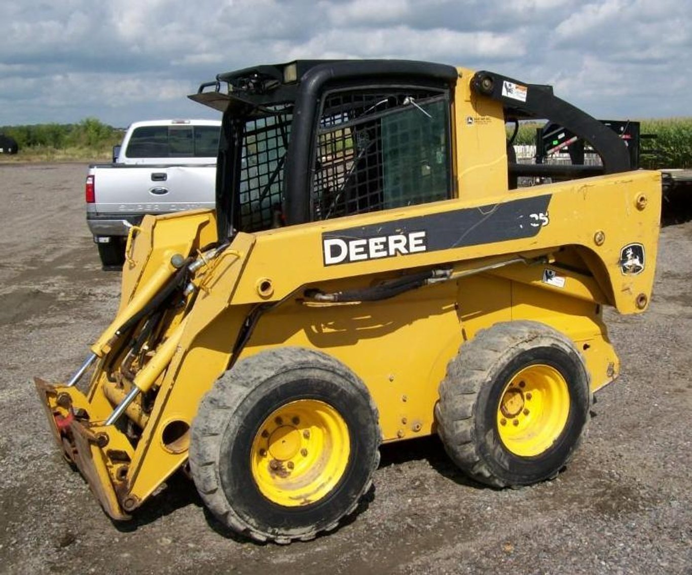 John Deere 325 Skid Steer, 2015 Delta 28' Gooseneck Flatbed, 2013 Sooner Aluminum Stock Trailer & Attachments